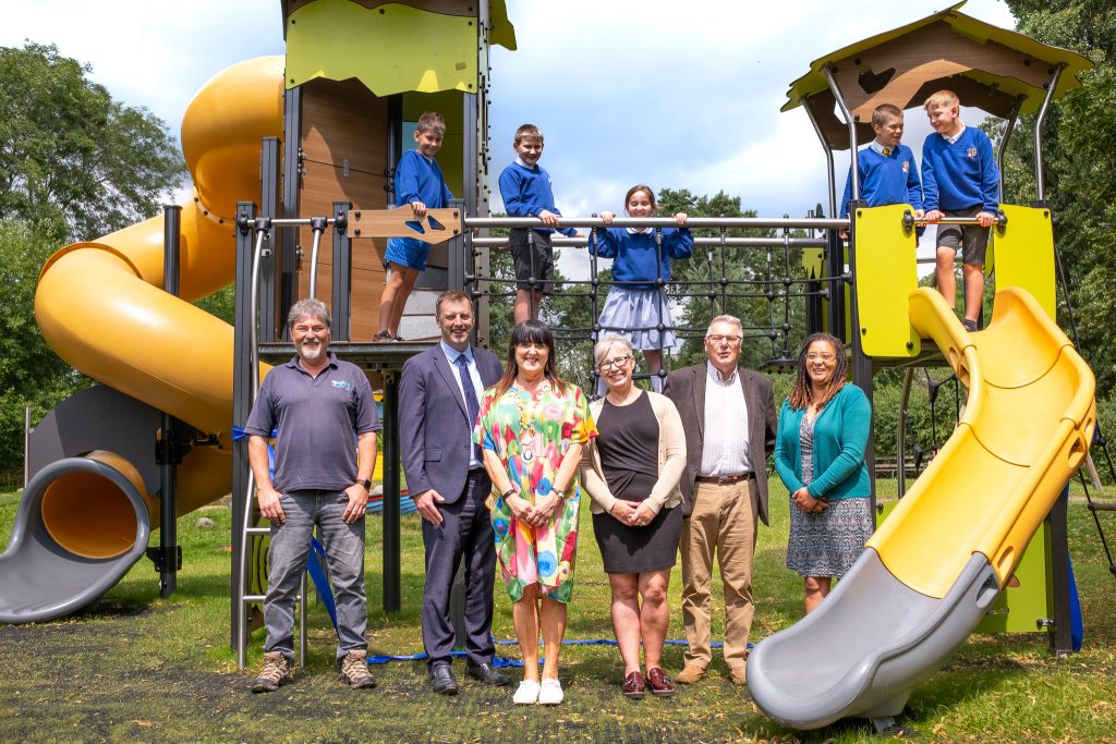 Children on a new play park, plus visiting adults